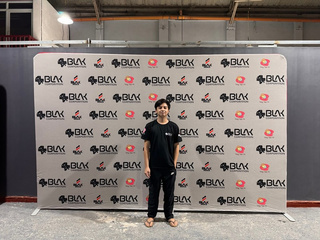 Wide printed BLAK Deals branded backdrop with a person beside it for scale